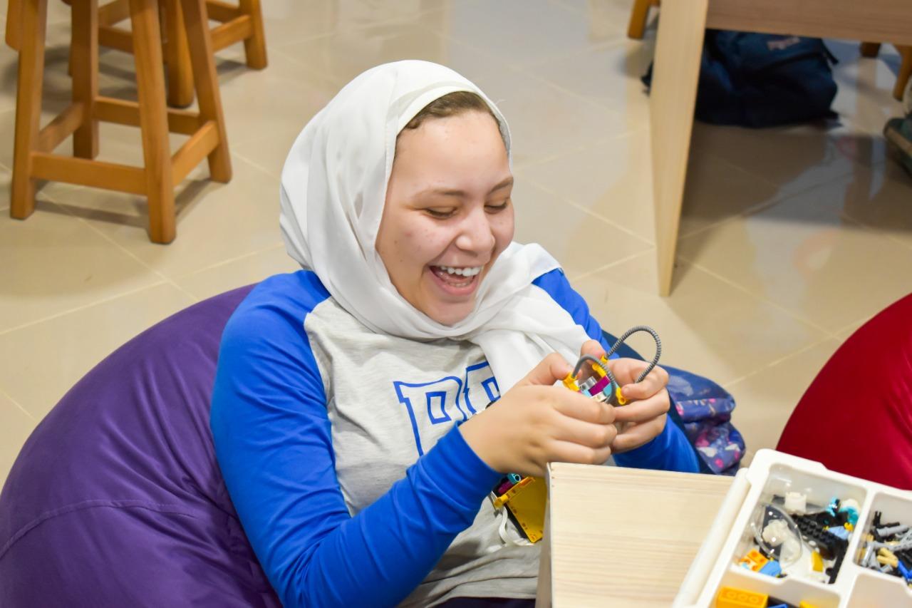 A student at IVY STEM International School joyfully engages in a STEM craft activity, exploring creativity and problem-solving with building materials.